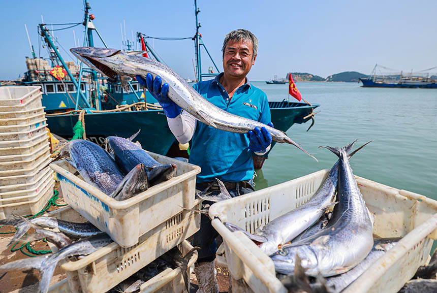 漁民在展示捕獲的大鲅魚。李信君攝