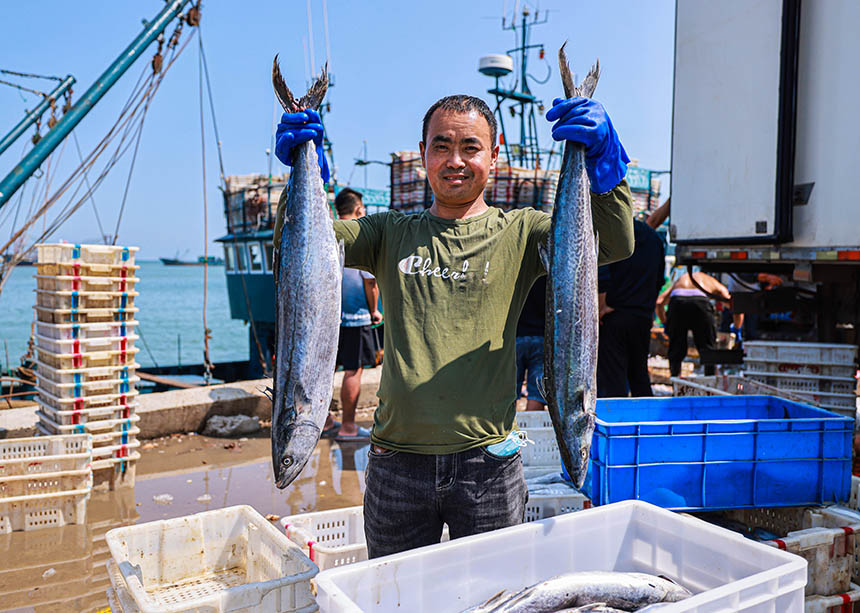 漁民在展示捕獲的大鲅魚。李信君攝
