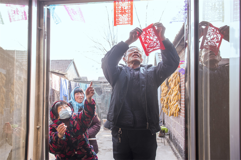圖為來逢強(qiáng)正在張貼“過門箋”。陳光金攝