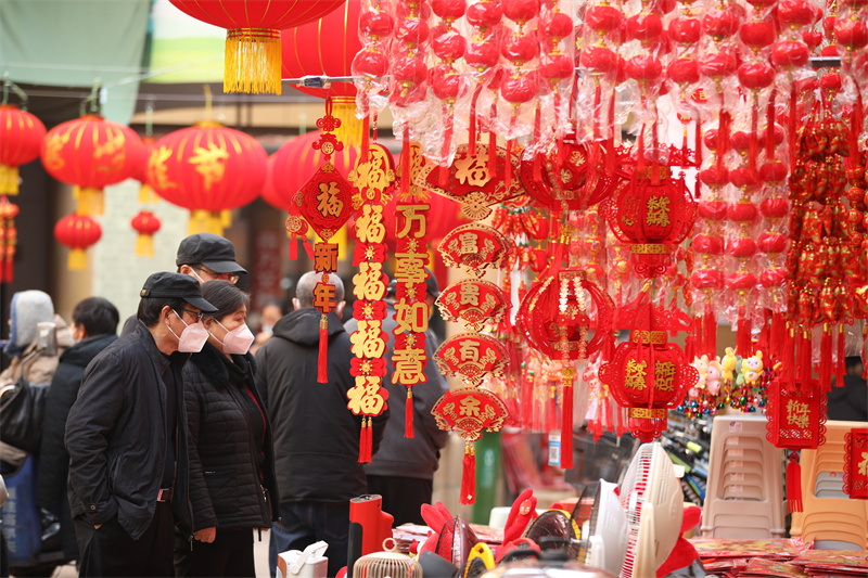 圖為市民在日照太陽城市場(chǎng)內(nèi)選購各類新年飾品。于坤帥攝