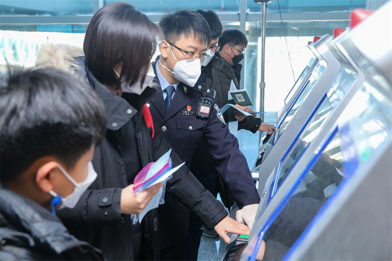 1月9日，山東出入境邊防檢查總站青島機場邊檢站民警引導(dǎo)旅客采集入境通關(guān)信息。解豪攝