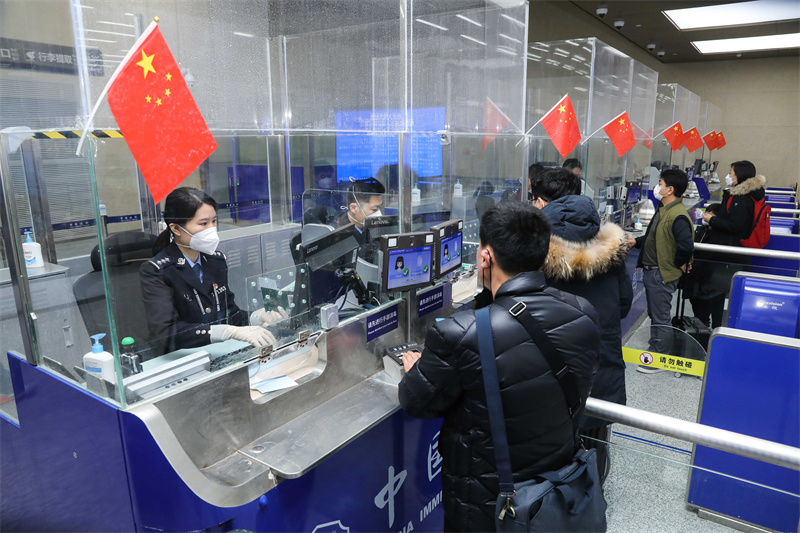 1月9日，山東出入境邊防檢查總站青島機(jī)場(chǎng)邊檢站民警為入境旅客辦理通關(guān)手續(xù)。解豪攝