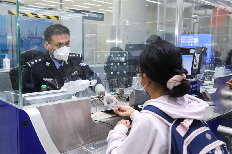 1月9日，山東出入境邊防檢查總站青島機場邊檢站民警為入境旅客辦理通關手續(xù)。解豪攝