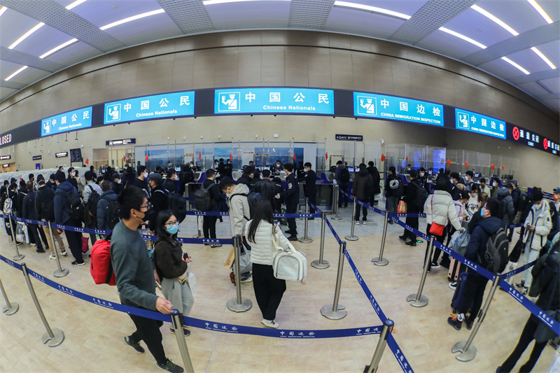 1月9日，山東出入境邊防檢查總站青島機場邊檢站民警為入境旅客辦理通關(guān)手續(xù)。解豪攝