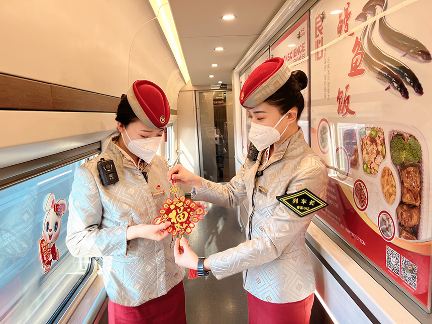 列車長張京和乘務(wù)員正在裝飾車廂。陳俊鳴攝