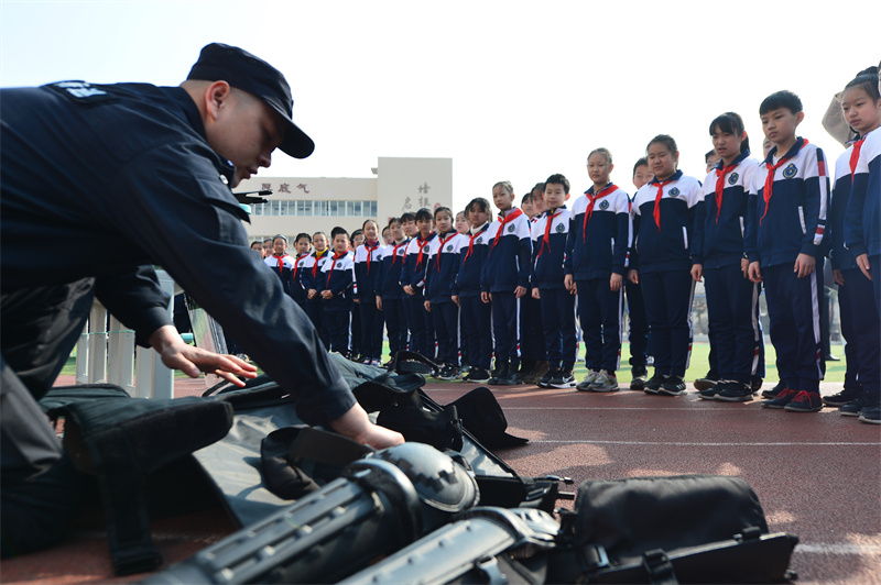 轄區(qū)民警向?qū)W生們介紹警用防護(hù)裝備。王海濱攝