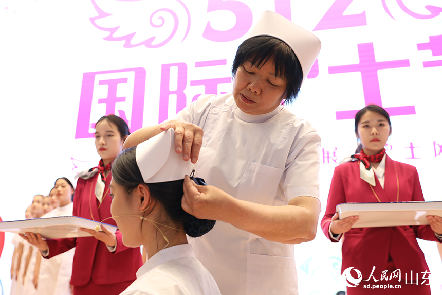 護(hù)理前輩為即將踏入實(shí)習(xí)崗位的學(xué)生授帽。人民網(wǎng)記者 劉祺攝