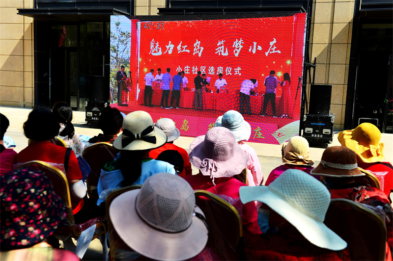 在回遷房選房現(xiàn)場，村民通過大屏幕觀看選房過程。王海濱攝