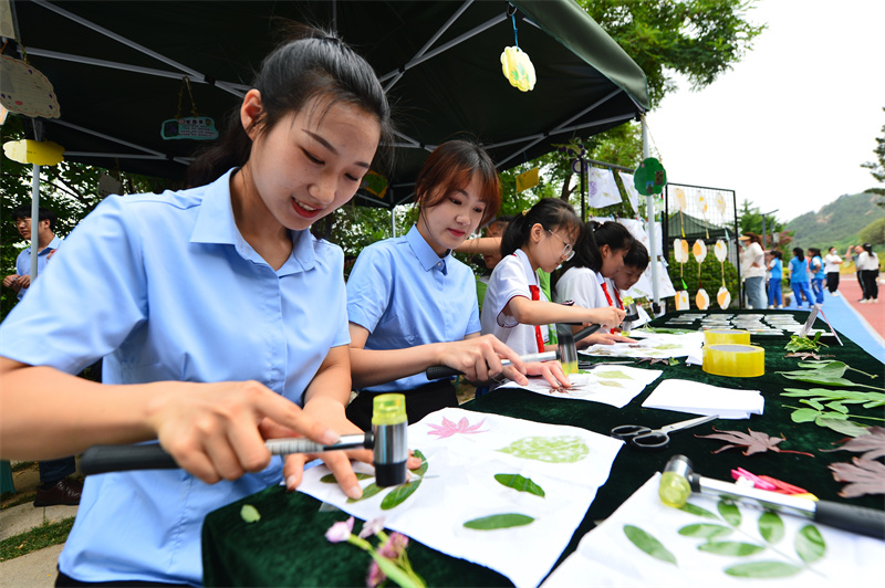 6月17日，在山東省青島市城陽區(qū)夏莊街道丹山森林公園，丹山小學(xué)的師生在制作樹葉拓印畫。王海濱攝