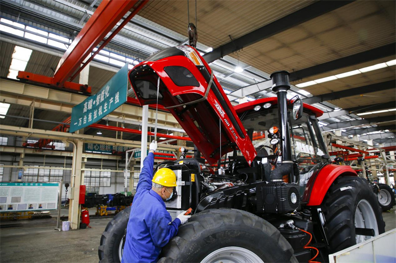 山東五征集團(tuán)有限公司工人在車間組裝生產(chǎn)大型農(nóng)機(jī)設(shè)備。王濤攝