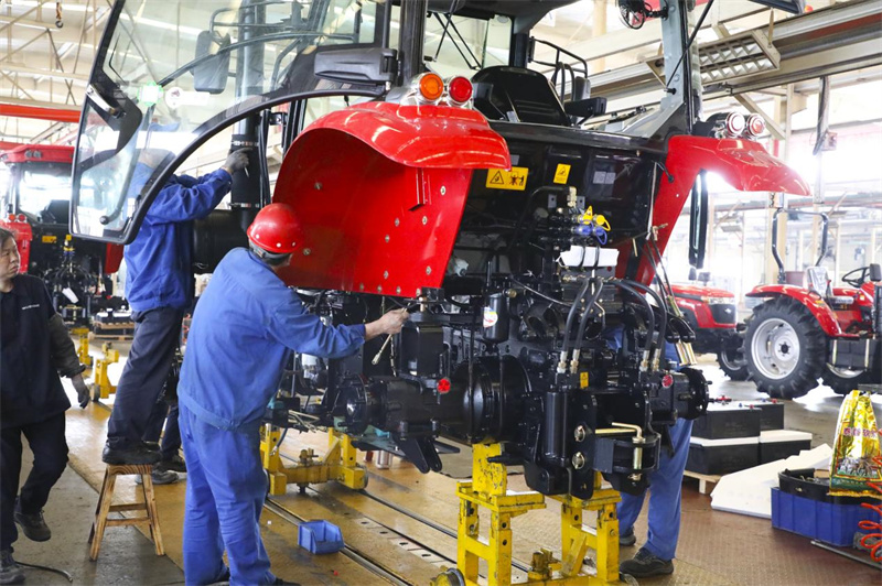 山東五征集團(tuán)有限公司工人在車間組裝生產(chǎn)大型農(nóng)機(jī)設(shè)備。王濤攝