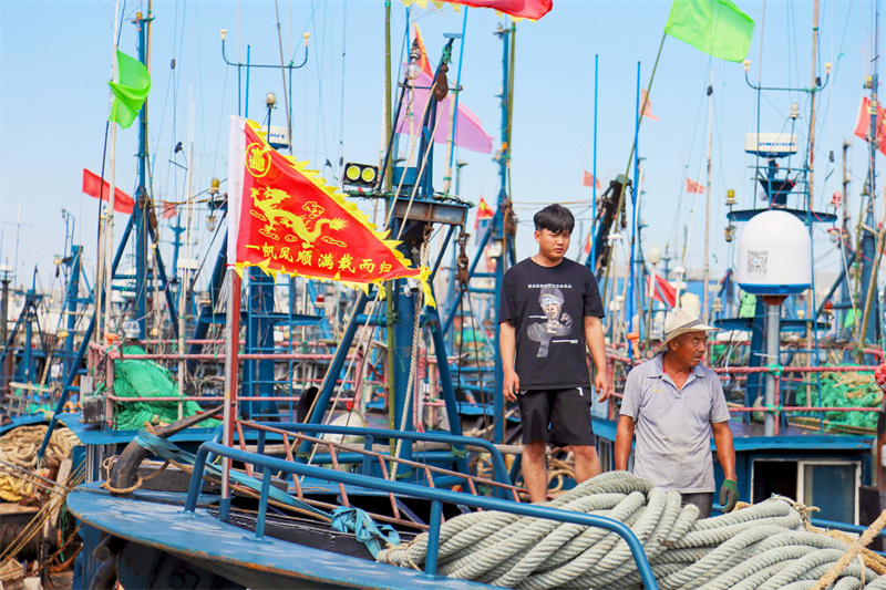 在日照黃海中心漁港內,漁民正在往船上裝物資。薄林攝