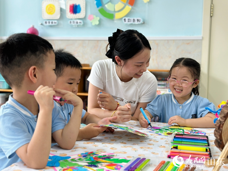 教師節(jié)前夕，在濟南市市中區(qū)樂山幼兒園，老師正在指導(dǎo)孩子們給繪畫作品涂色。人民網(wǎng) 喬姝攝