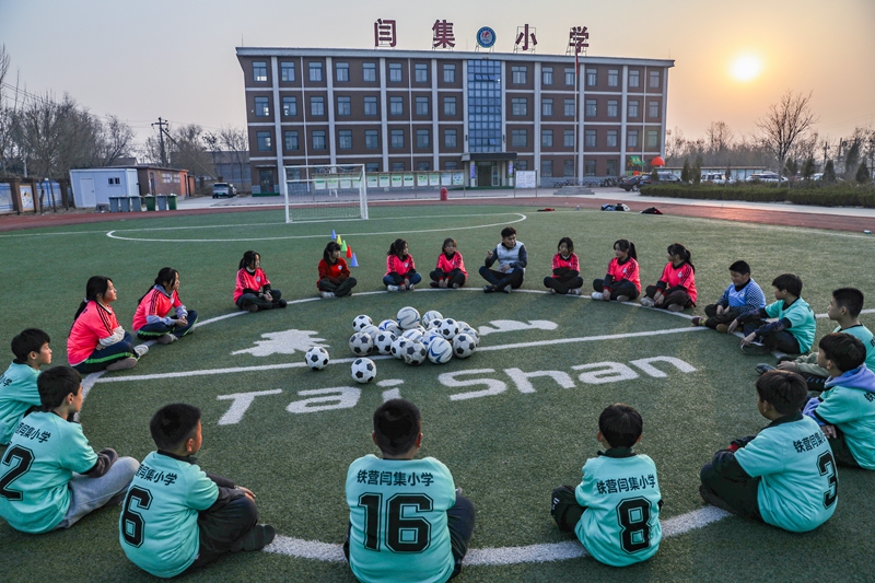 12月5日，老師在鐵營鎮(zhèn)閆集小學(xué)足球場跟學(xué)生們交流足球技能。