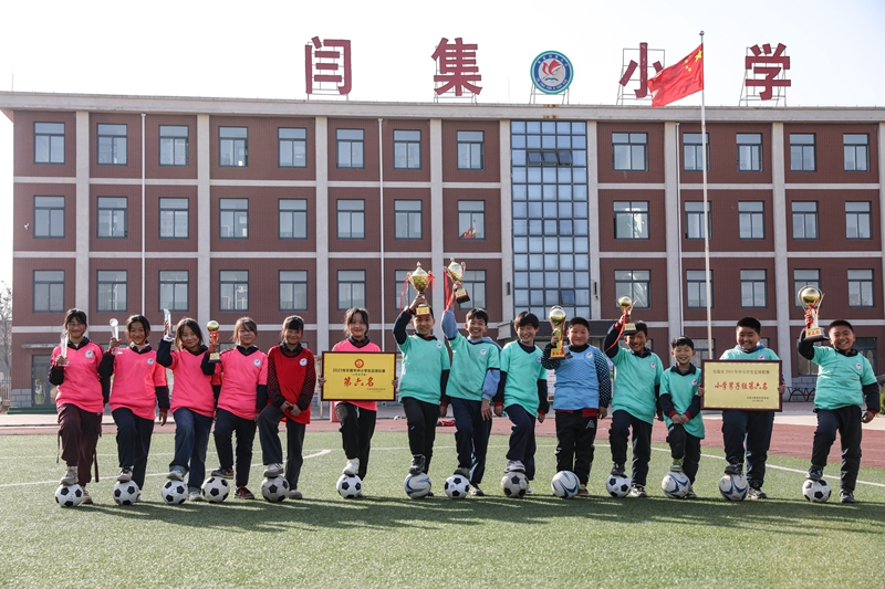 12月6日，學(xué)生們手持獲得的榮譽(yù)在鐵營(yíng)鎮(zhèn)閆集小學(xué)足球場(chǎng)開心地合影。