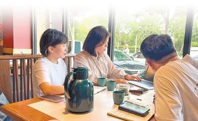 張文宇（左二）和客戶分析季度數(shù)據(jù)情況。梁之磊攝