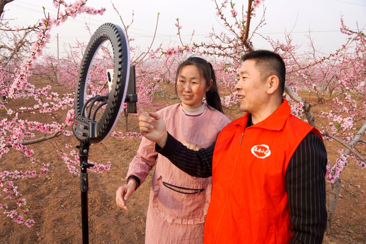 圖為客戶(hù)經(jīng)理協(xié)助零售客戶(hù)劉新燕開(kāi)展桃花節(jié)線上直播