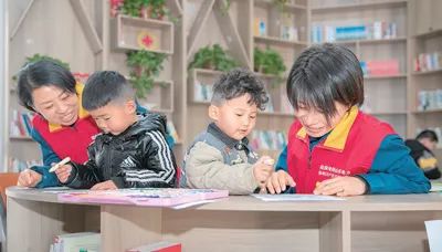 圖為滿玉林（左一）和志愿者陪社區(qū)孩子開展活動。王者東攝