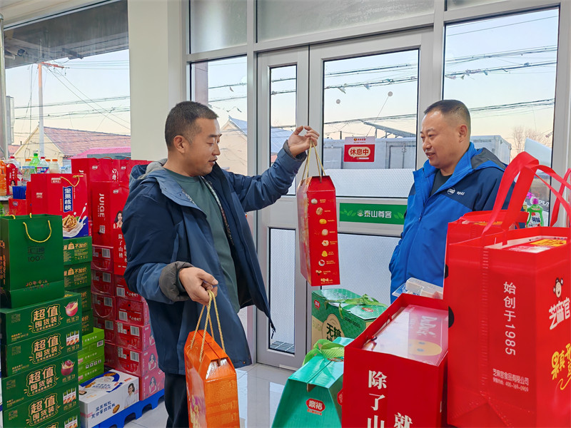 王金勇（左）與供應(yīng)商對接，提前備年貨禮盒