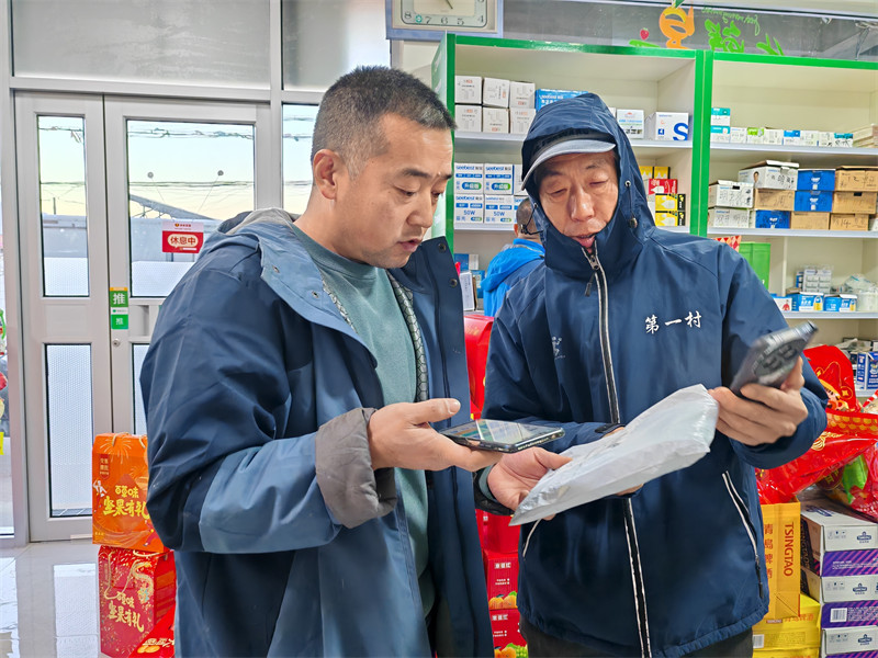 王金勇（左）幫助顧客收發(fā)快遞