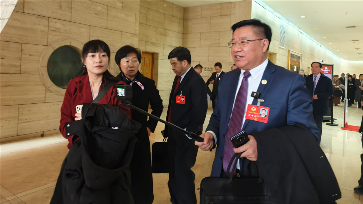 1月19日，山東省政協(xié)十三屆三次會議開幕，一位委員走出會場，邊走邊接受采訪。人民網(wǎng)記者宋翠攝