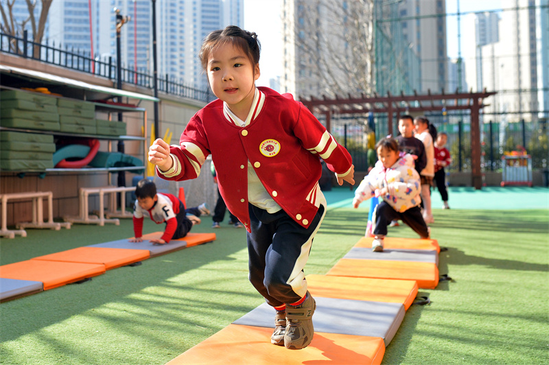 小朋友在山東青島高安路幼兒園開展的新學(xué)期“悅動(dòng)健康”主題課堂上參與“奔跑逐光”運(yùn)動(dòng)。王海濱攝