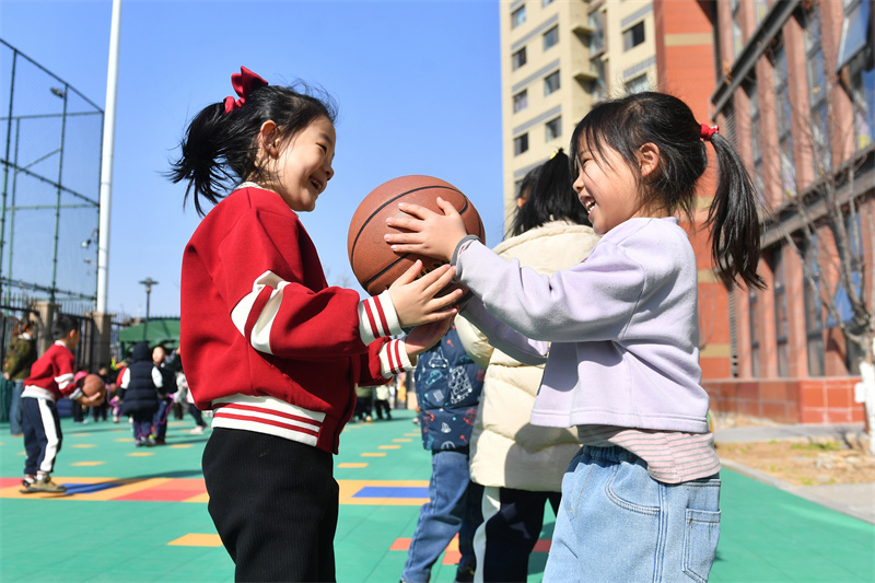兩名小朋友在山東青島高安路幼兒園開展的新學(xué)期“悅動健康”主題課堂上玩籃球游戲。王海濱攝