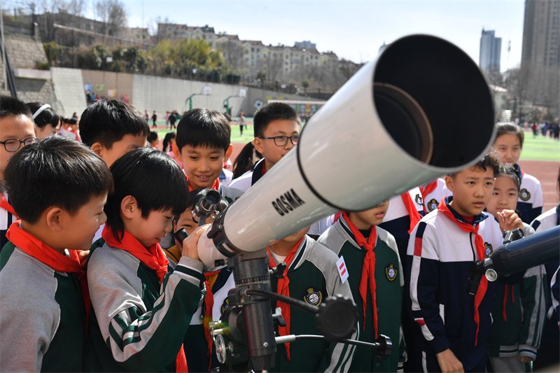 2025年3月13日，在山東青島寧安路小學(xué)開展的天文主題科普教育活動上，學(xué)生們在調(diào)試天文望遠鏡。