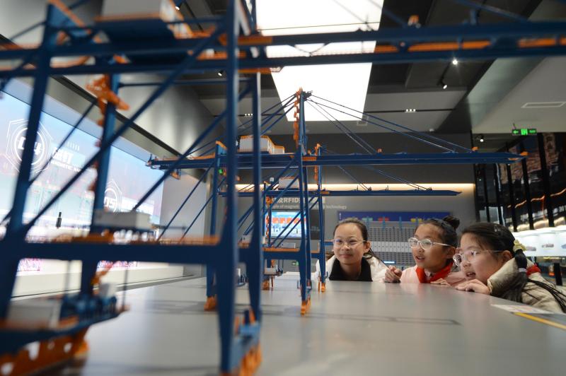 學(xué)生們?cè)谟^看岸邊集裝箱起重機(jī)模型。