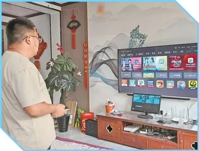 成植文調試新購入的智能電視。圖為李玉杰攝（人民視覺）