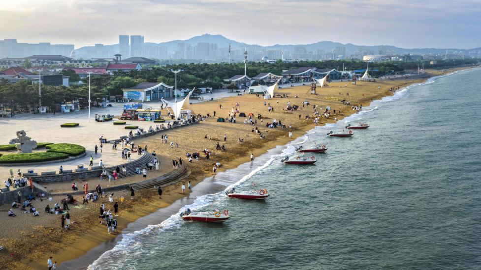 海濱沙灘上人潮涌動，游船逐浪，把熱鬧揉進海風里。單英攝