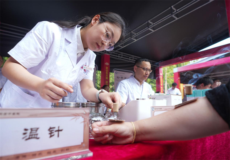 6月28日，在山東省鄒平市的夏季“黃河大集”中醫(yī)養(yǎng)生市集，醫(yī)生為顧客艾灸。