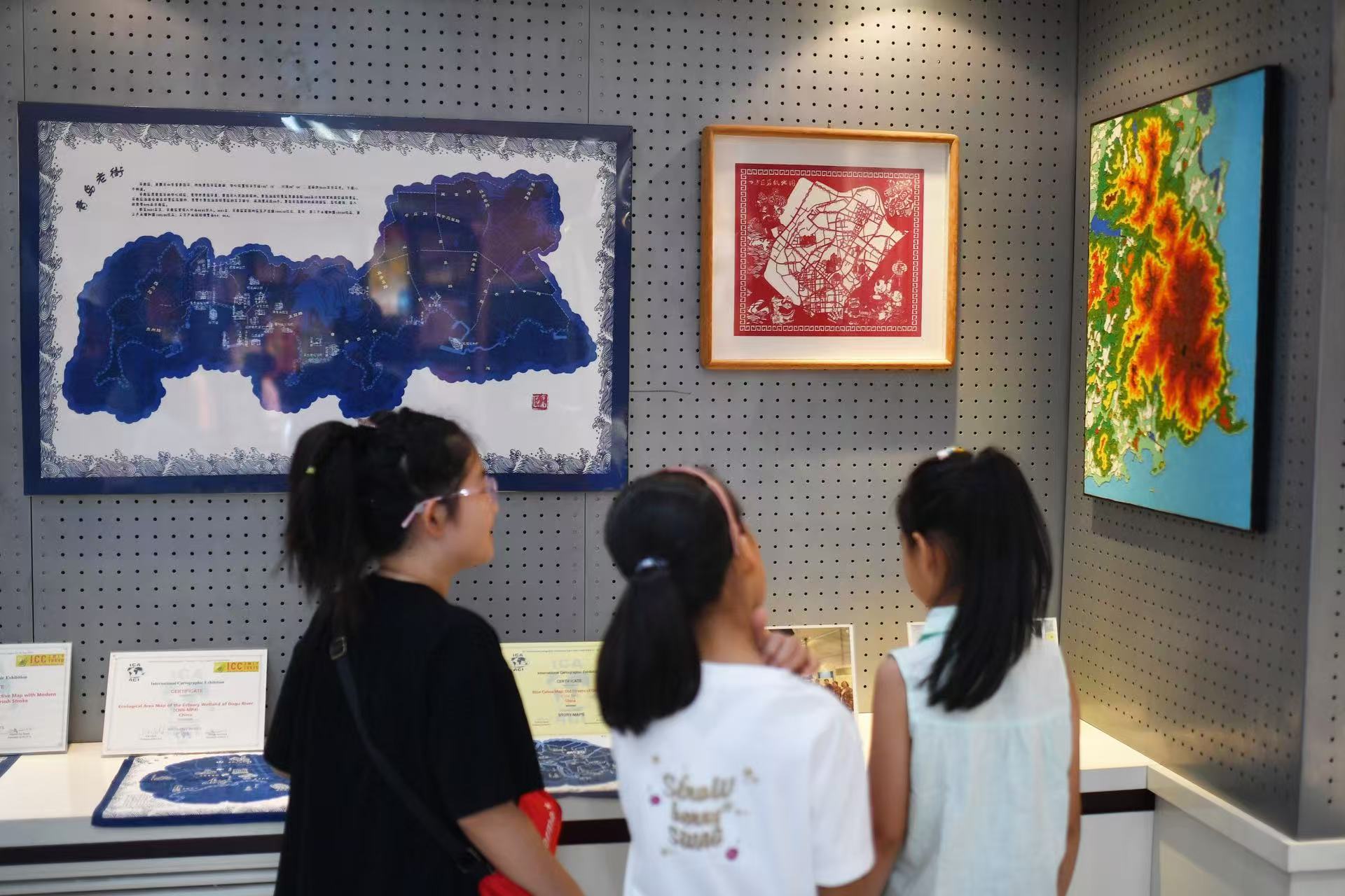 2025年8月9日，在山東省青島市勘察測繪研究院地圖文化展廳，嘉定路小學(xué)的學(xué)生在參觀青島老街地圖展。