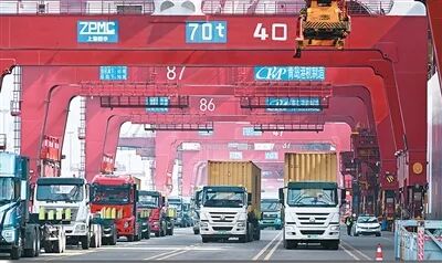 青島市上合示范區(qū)與青島港互聯(lián)互通，打造了“前港后站、一體運作”海鐵聯(lián)運服務(wù)模式。圖為貨車在山東港口青島港運送集裝箱。新華社記者 李紫恒攝