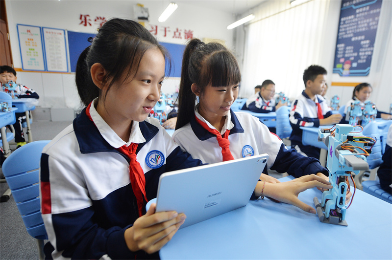 2025年9月25日，在山東省青島市市北區(qū)平安路第二小學(xué)開展的“校園科技之光”主題系列活動(dòng)上，兩名學(xué)生利用平板電腦編寫程序操控機(jī)器人。