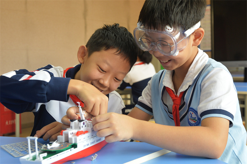 2025年9月25日，在山東省青島市市北區(qū)平安路第二小學(xué)開展的“校園科技之光”主題系列活動(dòng)上，兩名學(xué)生在安裝科考船模型。