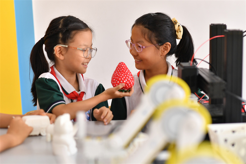 2025年9月25日，在山東省青島市市北區(qū)平安路第二小學(xué)開展的“校園科技之光”主題系列活動(dòng)上，兩名學(xué)生在觀看3D打印的草莓。