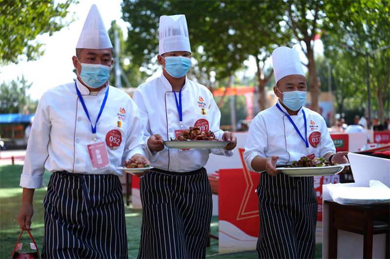 9月30日，在山東省鄒平市青陽鎮(zhèn)炒雞品鑒中心舉行的2025齊魯烹雞大賽上，參賽選手把做好的炒雞送到評比臺。