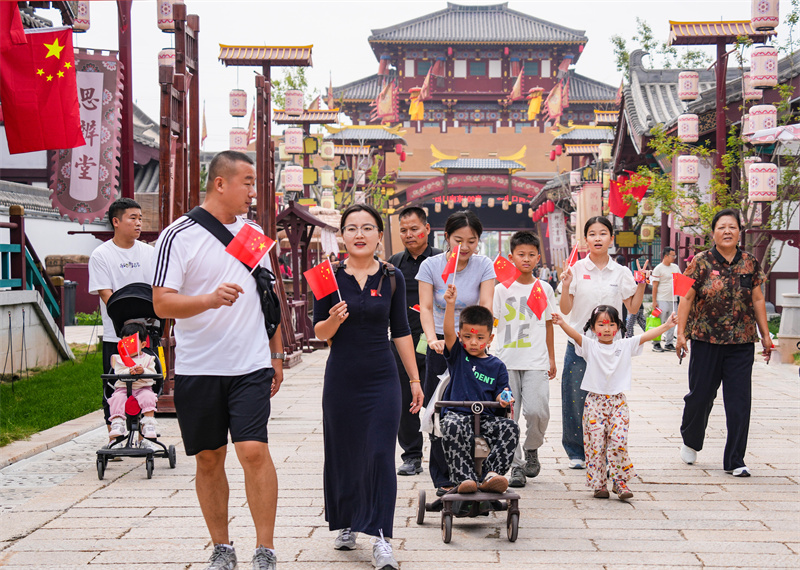 2025年10月1日，游客手持國旗在山東樂陵影視城游覽，“中國紅”成為一道風景線。