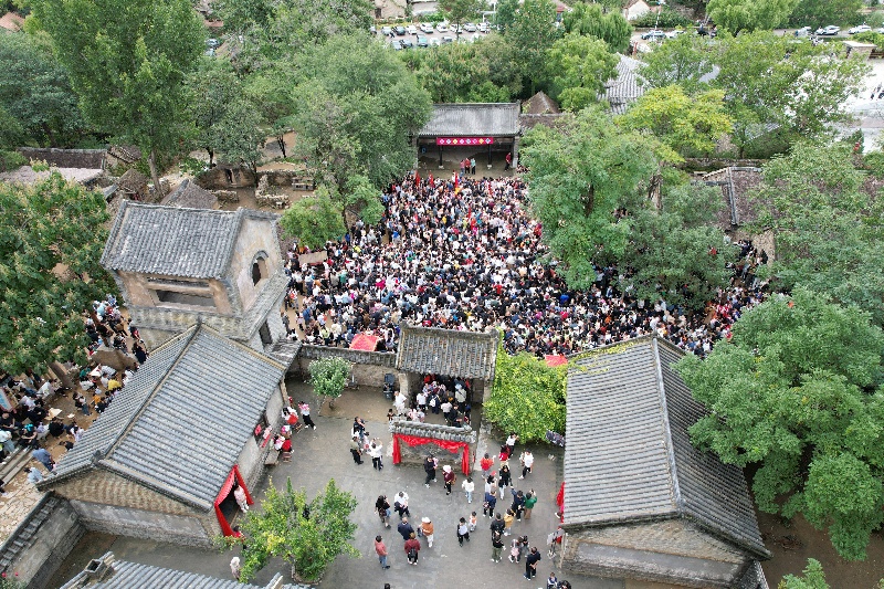 10月3日，在山東省臨沂市沂南縣常山莊村的山東紅嫂家鄉(xiāng)旅游區(qū)，游客在參與沉浸式互動演繹《重走支前路》（無人機照片）。