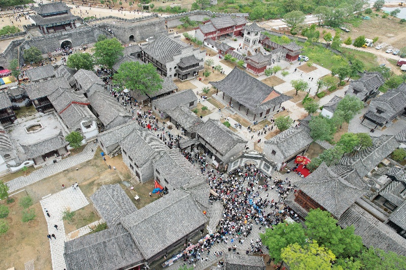  10月3日，在山東省臨沂市沂南縣常山莊村的山東紅嫂家鄉(xiāng)旅游區(qū)，游客在參與沉浸式互動(dòng)演繹《重走支前路》（無(wú)人機(jī)照片）。