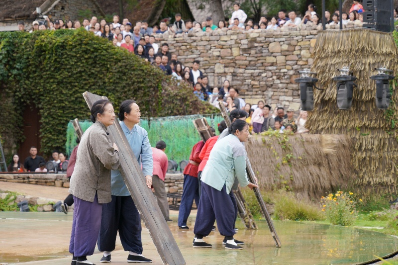 10月3日，在山東省臨沂市沂南縣常山莊村的山東紅嫂家鄉(xiāng)旅游區(qū)山村劇場(chǎng)，游客在觀看舞臺(tái)劇《火線橋》演出。