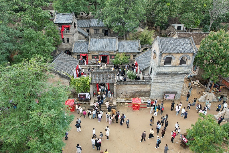 10月3日，在山東省沂南縣馬牧池鄉(xiāng)常山莊村的山東紅嫂家鄉(xiāng)旅游區(qū)，游客在熱播劇《生萬物》取景地打卡（無人機照片）。