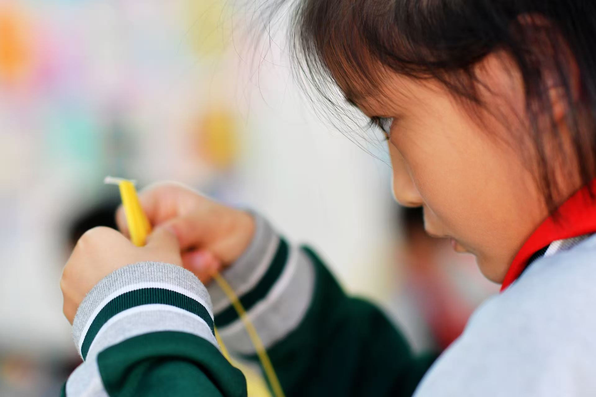 一名學生在學習衍紙畫卷紙