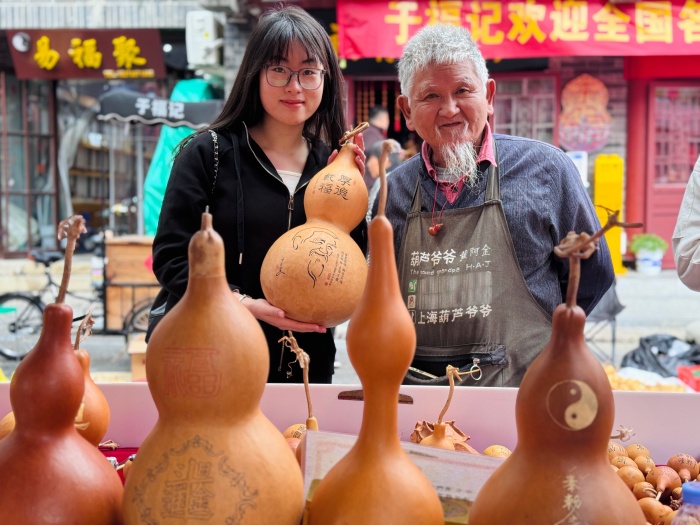 前來參展的葫蘆愛好者與手工藝人合影留念。人民網(wǎng) 鄭昕橋攝