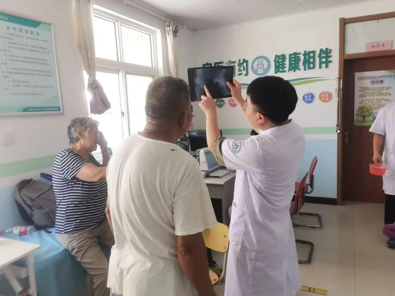 李春林耐心向老人解讀骨骼影像。受訪者供圖