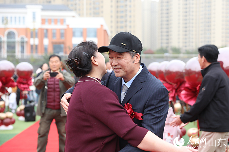 在濟南市高新區(qū)金谷小學“重溫芳華 共期金婚”活動現(xiàn)場，一對金婚老人深情相擁，重現(xiàn)數(shù)十年前的美好瞬間，定格了歷久彌堅的幸福。人民網(wǎng)記者 劉祺攝