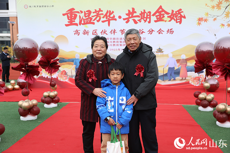 一對老人攜孫子在現(xiàn)場打卡合影。他們歷經(jīng)歲月沉淀的燦爛笑容，生動詮釋了“執(zhí)子之手，與子偕老”的動人畫面。人民網(wǎng)記者 劉祺攝