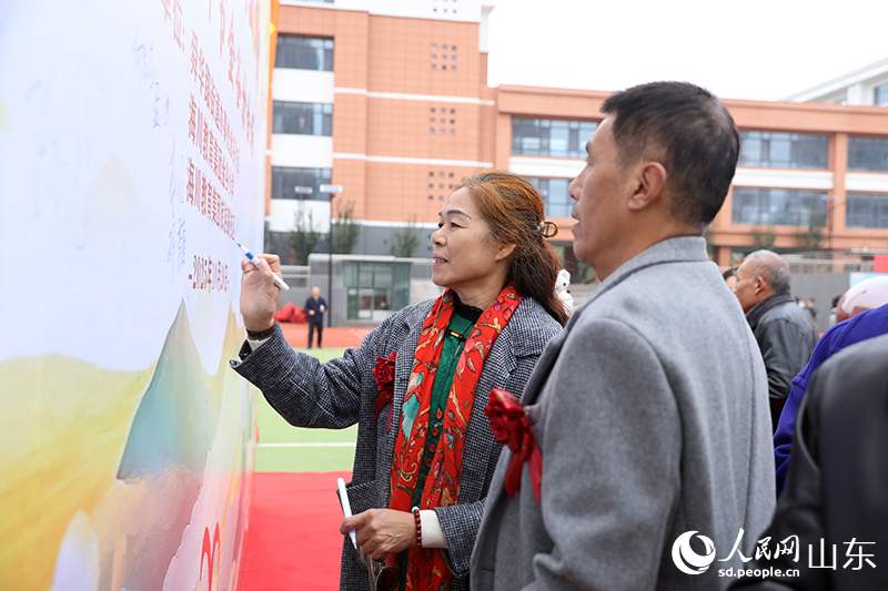 一對金婚夫婦在簽名墻上鄭重簽下自己的名字，以跨越半個世紀的筆觸，許下永恒的承諾。人民網(wǎng)記者 劉祺攝