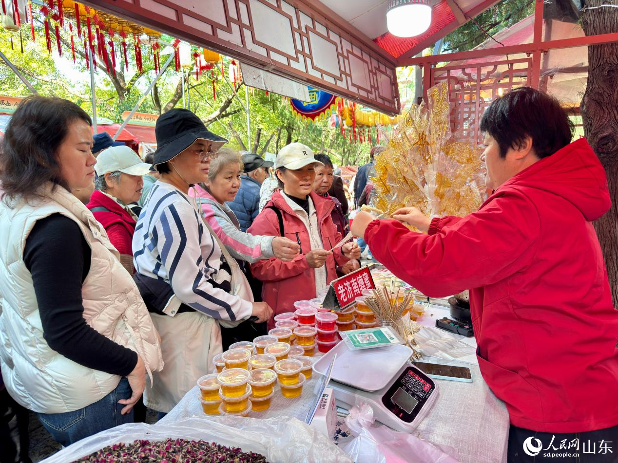 游客爭(zhēng)相體驗(yàn)、采購(gòu)老濟(jì)南纏蜜。人民網(wǎng) 鄭昕橋攝